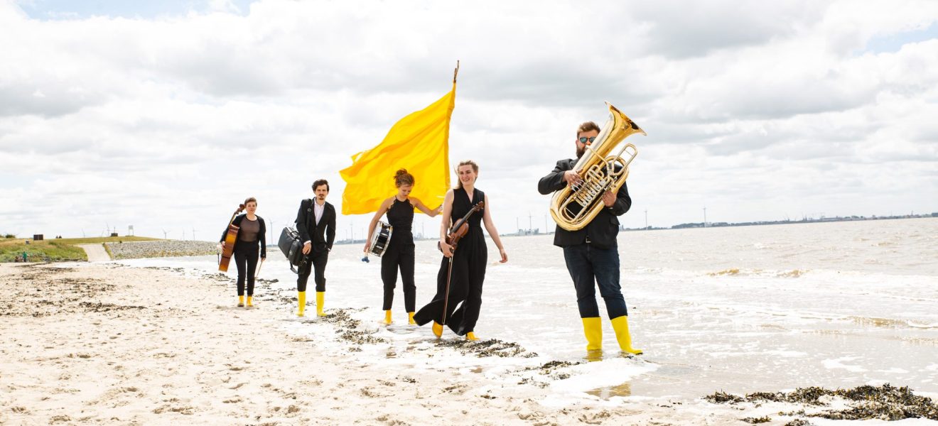Musikerinnen und Musiker am Strand.