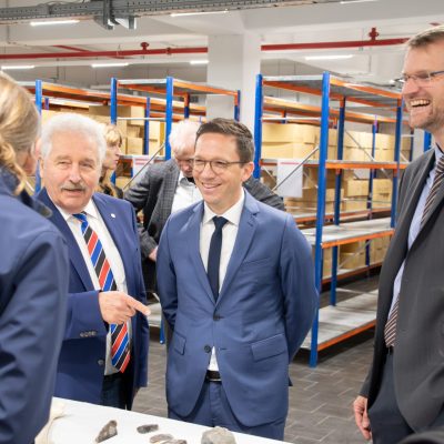 Landschaftspräsident Rico Mecklenburg, Minister Falko Mohrs und Landschaftsdirektor Dr. Matthias Stenger informieren sich über die archäologische Sammlung.